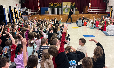 Students in audience participate in a performance