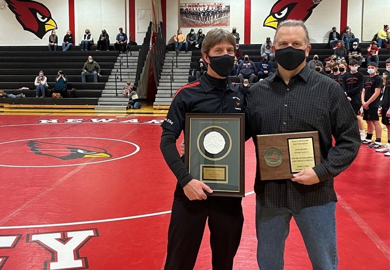 Two men with plaques in gym
