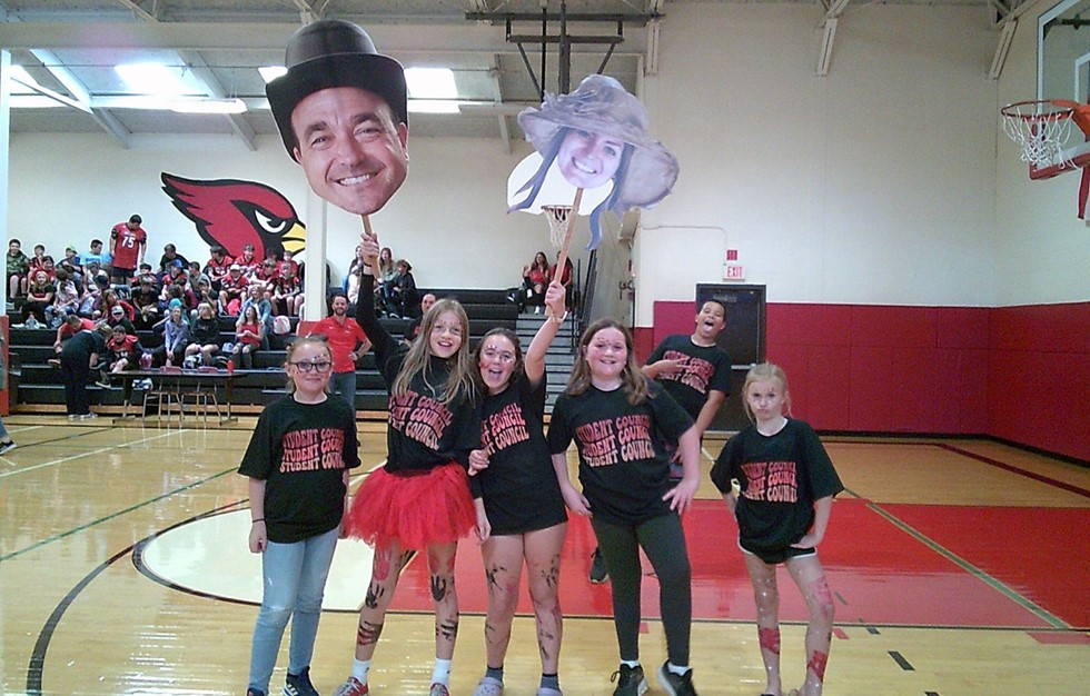 Middle school students smiling for a photo at a pep rally