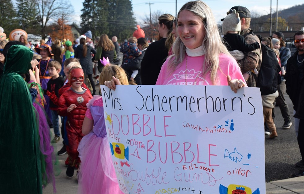 teacher holding sign with her class name on it