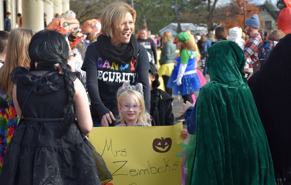 teacher holding sign with her class name on it