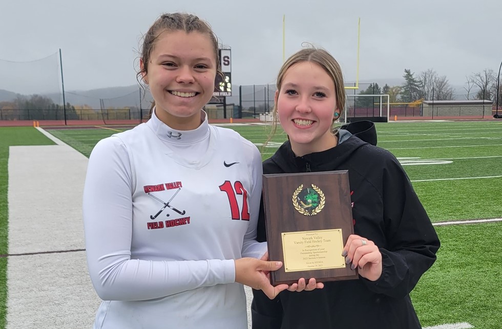 students smiling holding the varsity field hockey sportsmanship award