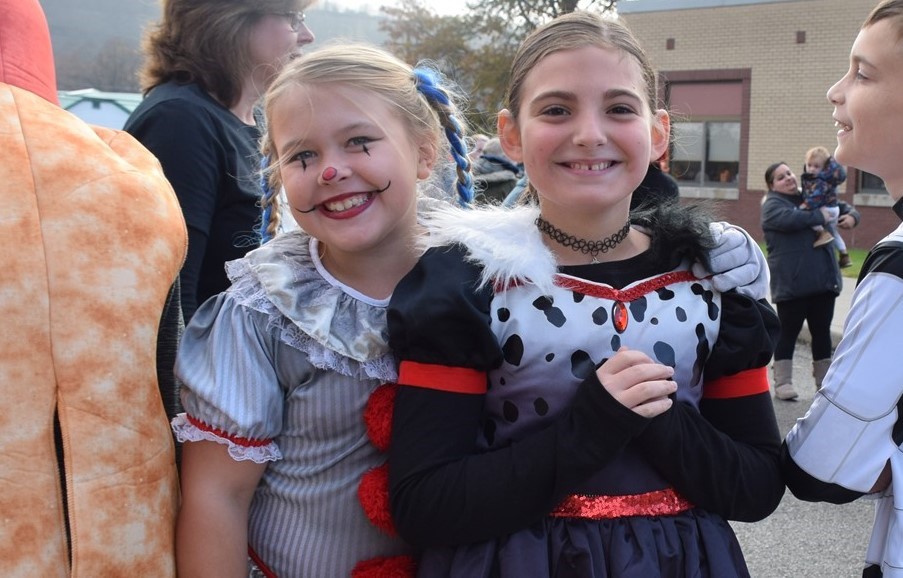 two students in halloween costumes smiling at the camera