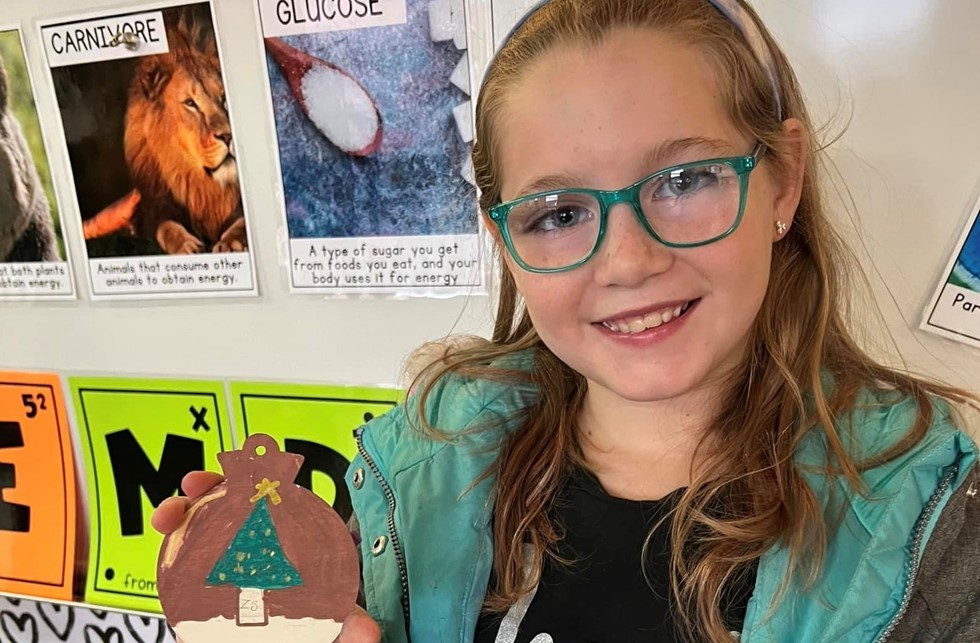 student holding ornament they created