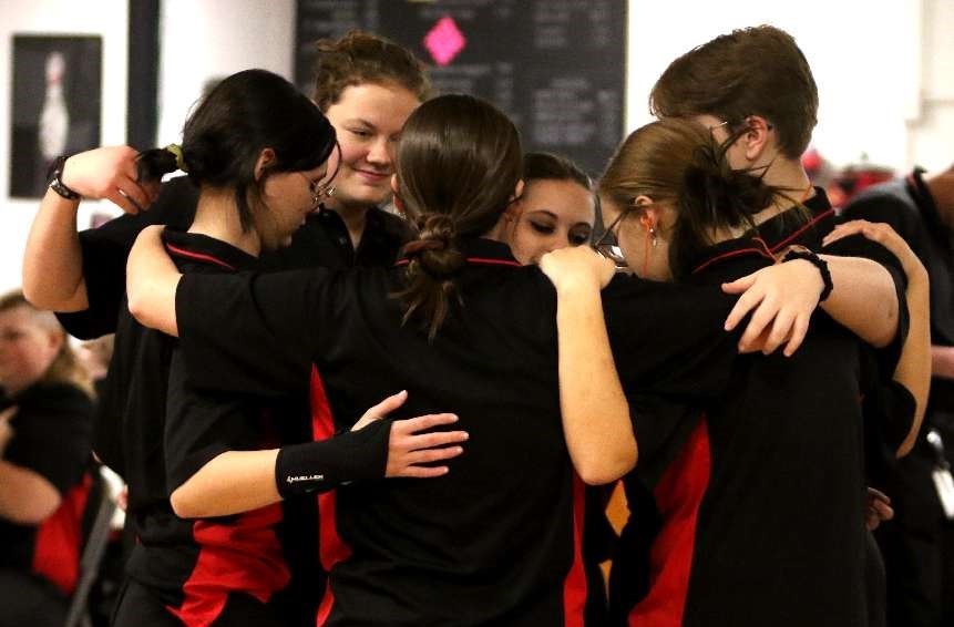 girls bowling team huddling