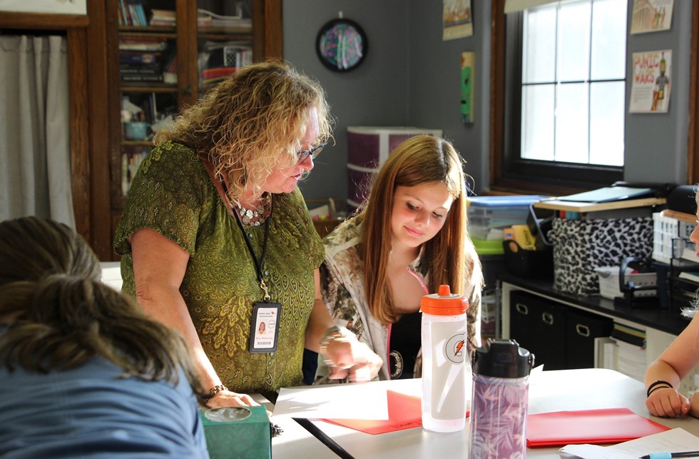 Teacher helping student in classroom