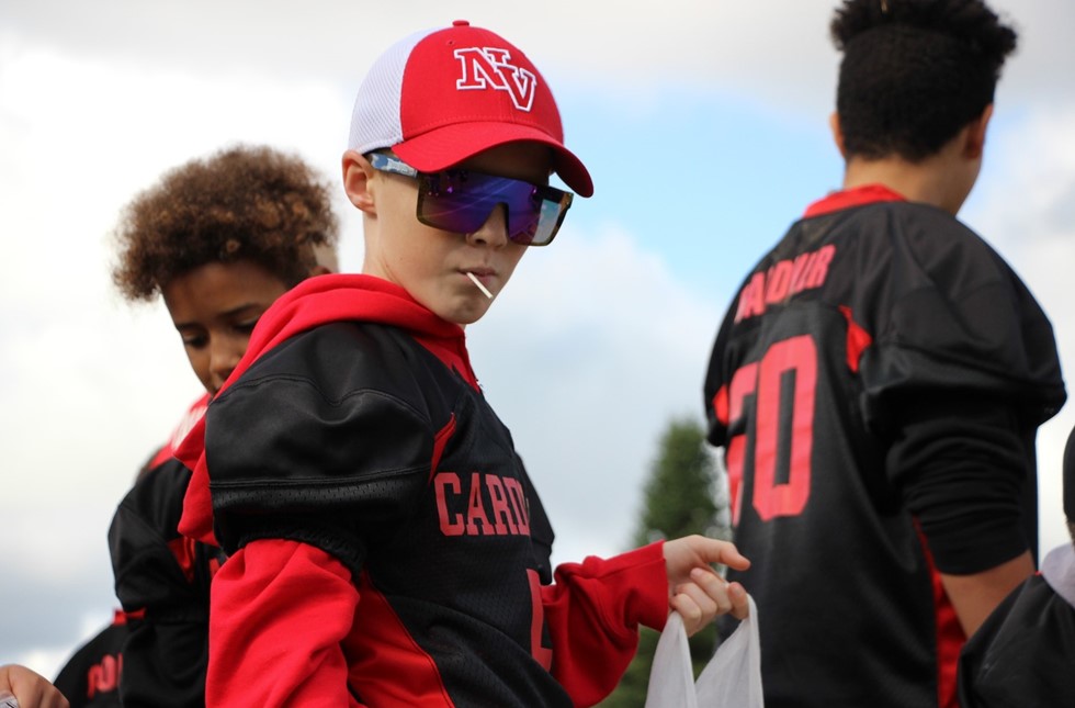 student in sunglasses and baseball hat on a float for parade