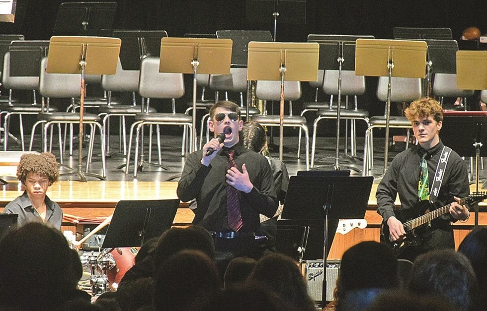 students singing and playing instruments at a concert 