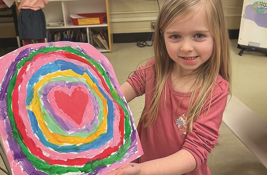 Student holding their Valentines Day Art Project 