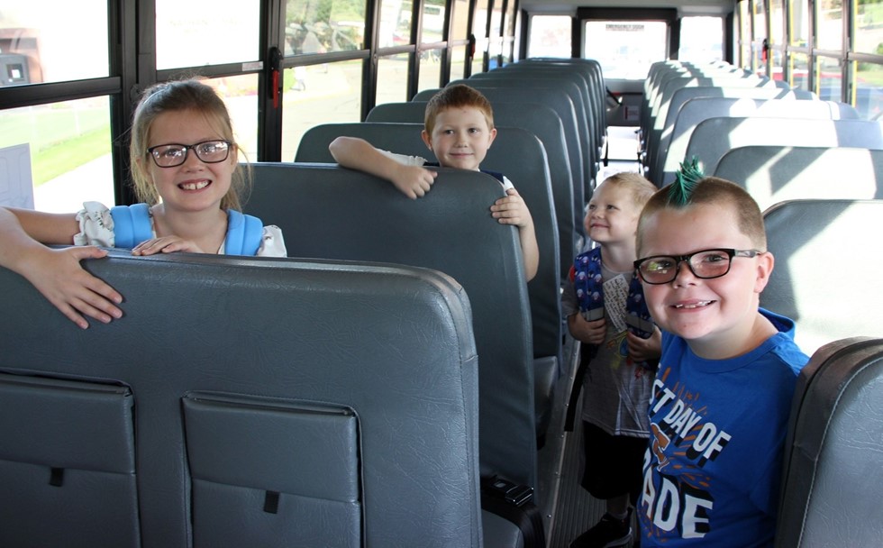 Students smiling on a bus 