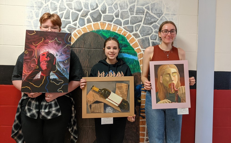 Three students with artwork