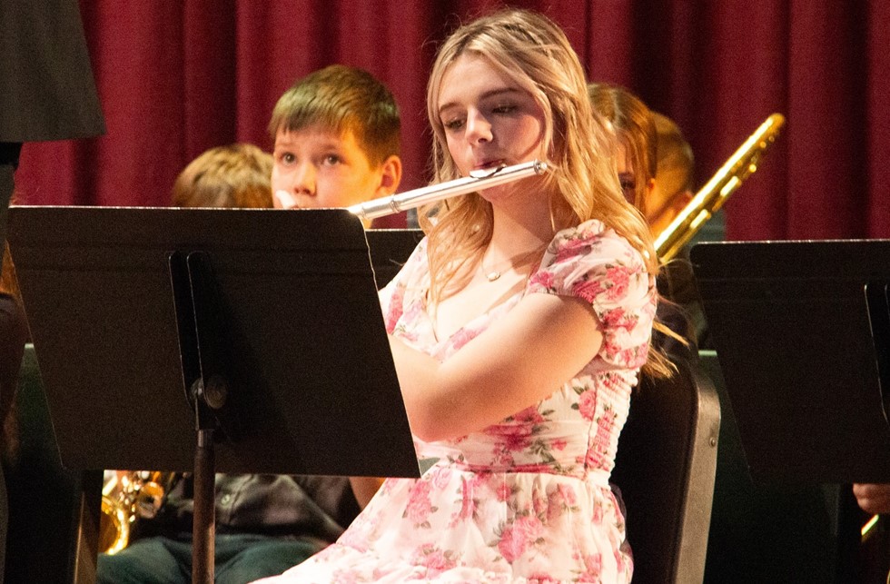 A middle schooler performing with a flute